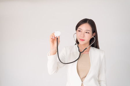 Medical, treatment, doctor, clinical, hospital, diagnosis, health checkup concept. Beautiful asian woman female doctor holding sthetoscope isolated on white background with copy space.の写真素材