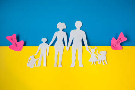representation of a Ukrainian family in the exodus to leave the country. paper cutout on the colors of the Ukrainian flag. Migration concept.の写真素材