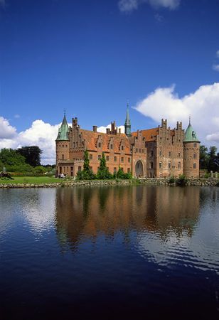 the egeskov castle in denmark mirroring in the waterの写真素材