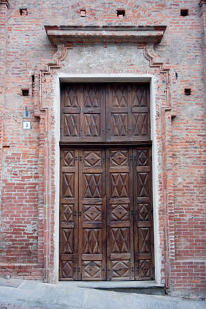 ancient wood door in Saluzzo, a beautiful town in Italyの写真素材