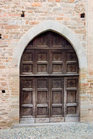 ancient wood door in Saluzzo, a beautiful town in Italyの写真素材