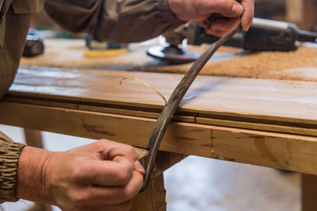 close up of carpenter's hand using a manual planer on wood