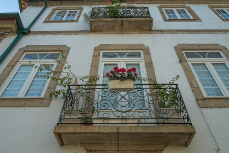 Facade of a typical portuguese building with flowers on windowの写真素材