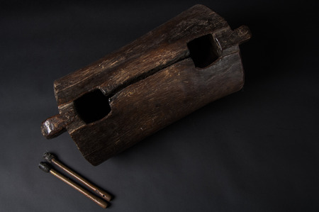 instrument of African music, drum made of wood with two bakets, isolated on dark backgroundの写真素材