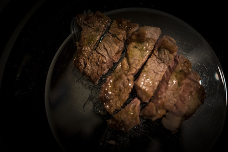 Piece of beef tenderloin to be cut into black dishの写真素材