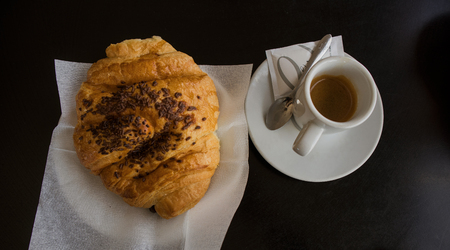 Croissant and cafe with black table on backgroundの写真素材