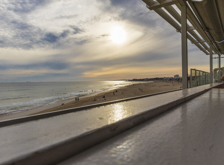 Restaurant bench overlooking the beach with sunsetの写真素材