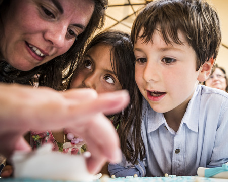 AMADORA/PORTUGAL-25 AUG 2015-Mother helping children with birthday cakeのeditorial素材
