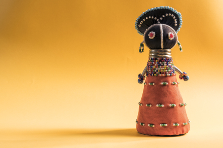 African cloth doll isolated on yellow backgroundの写真素材