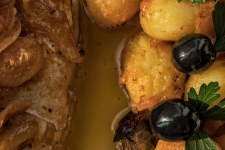 Fish baked in the oven, golden with boiled potatoes and olives in white dish. Typical Portuguese...