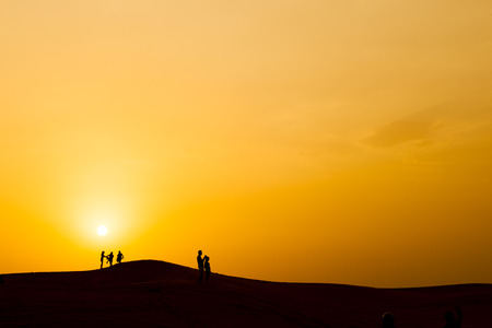 Silhouette of people in dubai desert, with sunset.の写真素材
