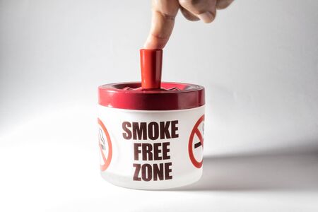 Ashtray with message, smoke free zone and finger of manの写真素材