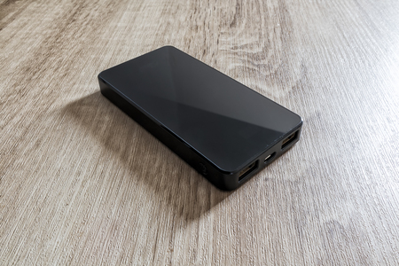 power bank phone charger isolated on wooden backgroundの写真素材
