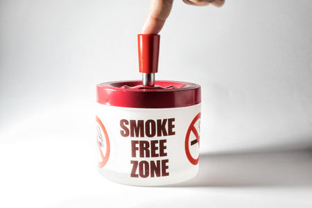 Ashtray isolated on white background, with the saying smoke free zone. Human finger.の写真素材