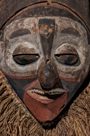 Hand made African mask with ropes simulating hair. Human face. Isolated on black background. close upの写真素材