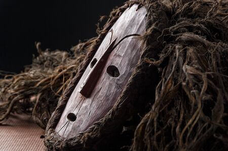 African wooden mask, with hair isolated on black background. close up.の写真素材