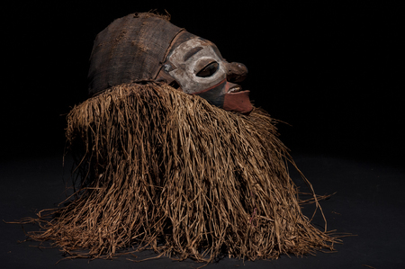 Hand made African mask with ropes simulating hair. Human face. Isolated on black background.の写真素材