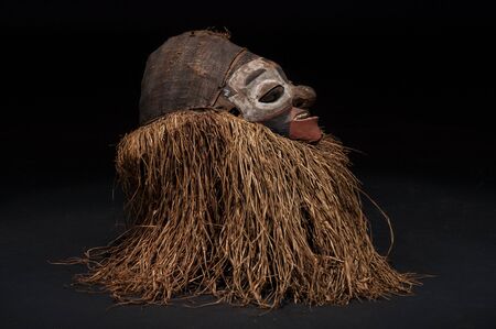 Hand made African mask with ropes simulating hair. Human face. Isolated on black background.の写真素材