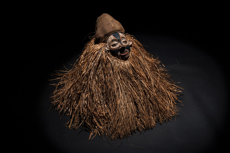 Hand made African mask with ropes simulating hair. Human face. Isolated on black background.の写真素材