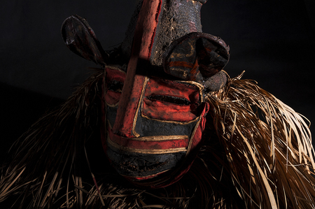 Hand made African mask with ropes simulating hair. Human face. Isolated on black background.の写真素材