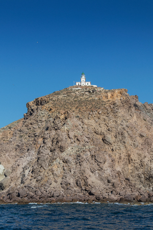 Cliff with lighthouse at top in Santorini.の写真素材