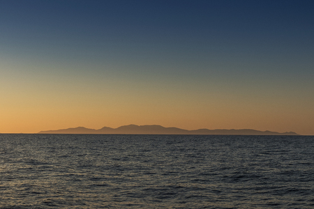 silhouette of santorini island seen from the sea. With sunset.の写真素材