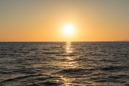 Beautiful sunset seen from the sea. Santorini, Greece.の写真素材