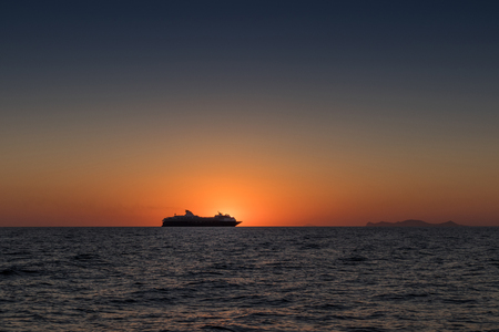 Beautiful sunset in Oia, Santorini. With silhouette of luxury cruise.の写真素材