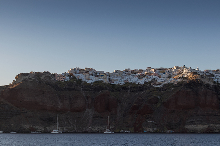 sunset seen from the sea of oia town with sailboat.の写真素材