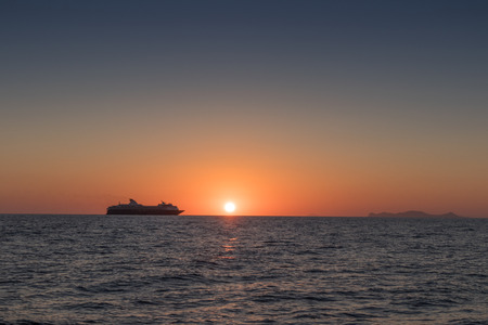 Beautiful sunset in Oia, Santorini. With silhouette of luxury cruise.の写真素材