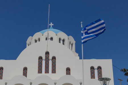Greek church in Santorini with Greek flag.の写真素材