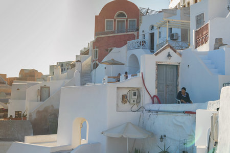 SANTORINI/GREECE 06 SEP 2017 - Beautiful sunset in Oia with old women seated. Santorini. Greece.のeditorial素材
