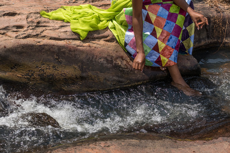 Woman in African outfit on the verge of fluent river. Interacting with water. Angola.の写真素材
