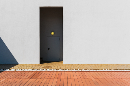 Minimalist door with white wall and red floor.の写真素材