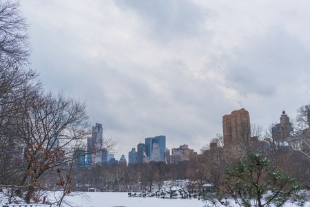 Lake in frozen central park with view of city in background, New York.の写真素材