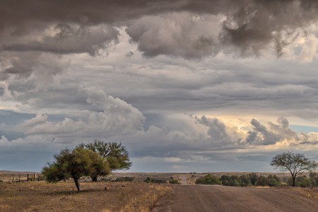 Gravel road en route to the Namibian desert with extremely dramatic sky, storm.の写真素材