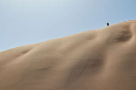 People climbing dune in the Namibia desert. Sossusvlei.の写真素材