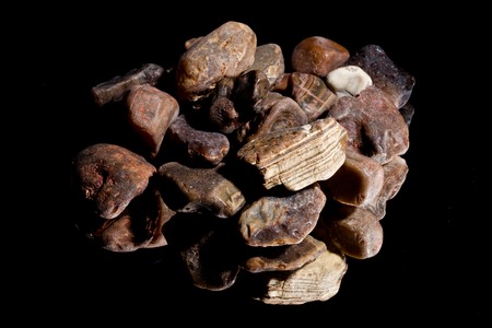 Ore from a diamond mine. isolated on black background with reflexion.の写真素材