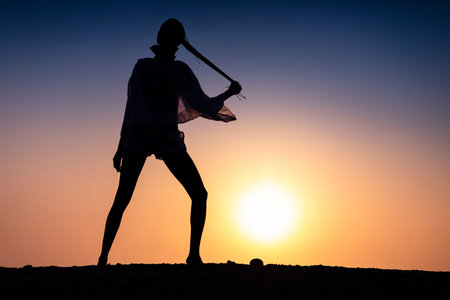 Silhouette of African girl on hill top posing and dancing with sunset view and ocean view.の写真素材