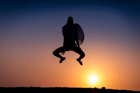 Silhouette of African girl on hill top posing and dancing with sunset view and ocean view.