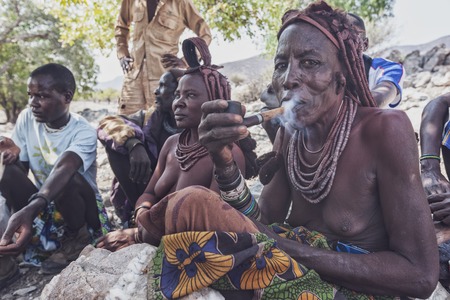 NAMIBE/ANGOLA - 28 AUG 2013 - Portrait of African elderly woman belonging to a tribe smoking with pipe.のeditorial素材