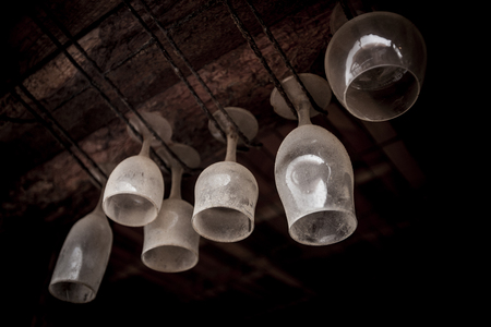 Dusty bar glasses hung upside down.の写真素材
