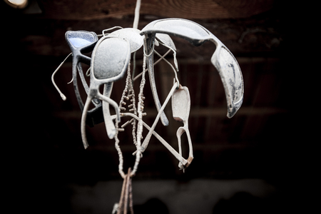 Set of sunglasses old and dusty by a rope, viewed from below.の写真素材