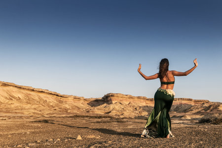 Active woman dancing on plain of the Namibe Desert. Africa. Angola.