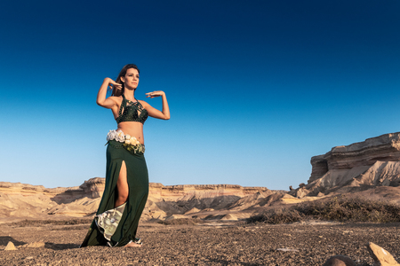 Woman dancing to the famous belly dance with natural sunset light, in the Namibe Desert with canyons. Africa. Angola.の写真素材
