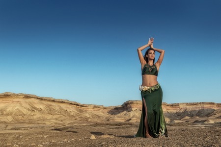 Woman dancing to the famous belly dance with natural sunset light, in the Namibe Desert with canyons. Africa. Angola.の写真素材