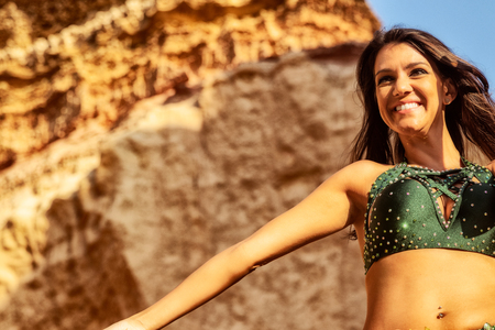 Young girl in green dress dancing the famous belly dance, in the mythical space of the canyons of the Namibe desert. Africa. Angola.の写真素材