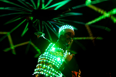 ABUDHABI/UAE - 17 DEZ 2018 - Traditional Arabic dance in Abu Dhabi, man dancing with dark environment and suit with green lights.のeditorial素材