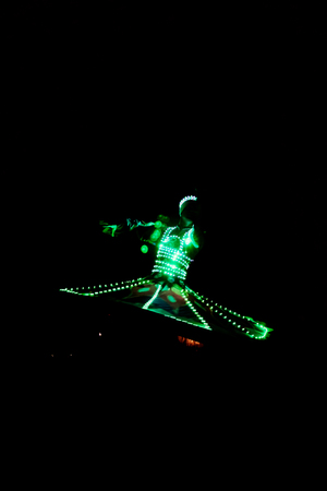 ABUDHABI/UAE - 17 DEZ 2018 - Traditional Arabic dance in Abu Dhabi, man dancing with dark environment and suit with green lights.のeditorial素材