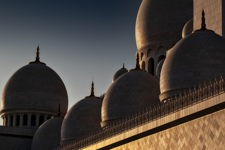 Cupolas in great mosque, abu dhabi, with sunset lightの写真素材